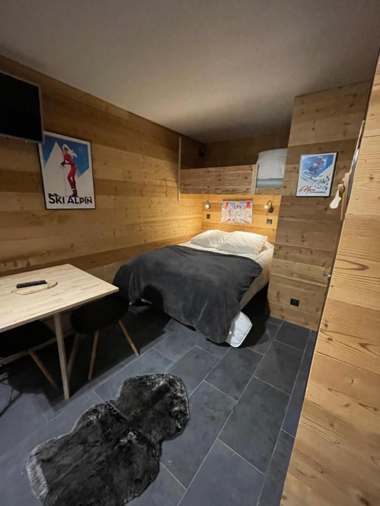 Cette chambre comprend un lit, une table et un bureau. dans l'établissement Home Vars. Le studio, à Vars