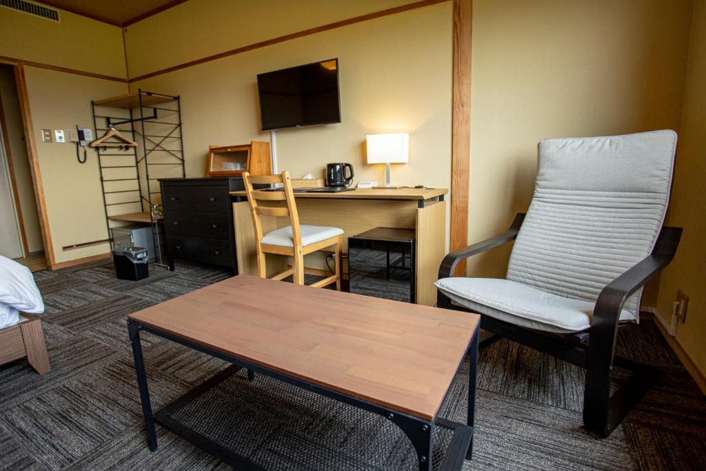 une pièce avec un bureau, une chaise et une table dans l'établissement Togari Onsen Alpen Plaza, à Iiyama