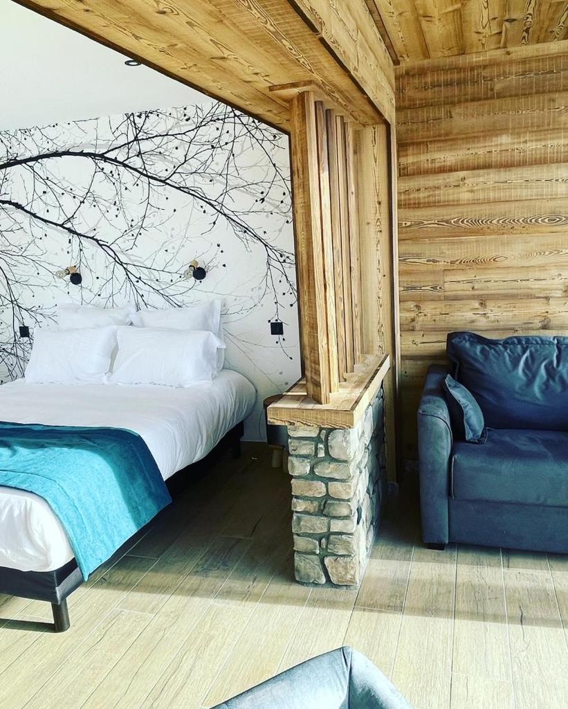 une chambre avec un lit et une chaise dans une pièce dans l'établissement Appart Hôtel Le JAS, à Ancelle
