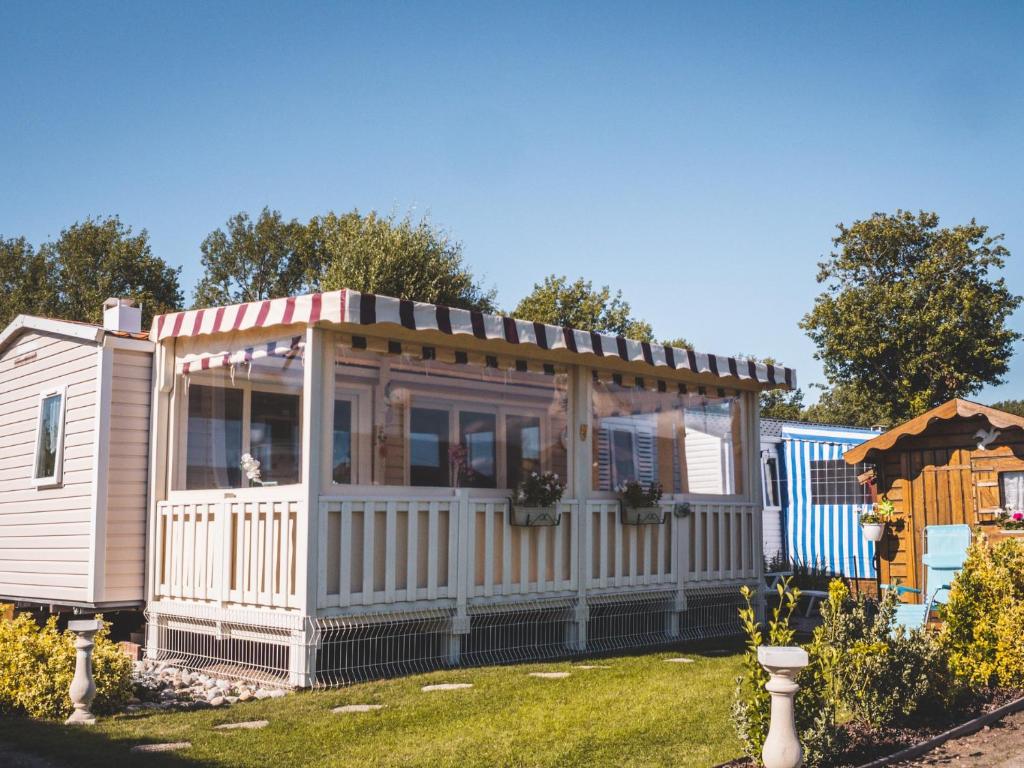 une petite maison avec un toit sur une cour dans l'établissement Camping Les Garennes, à Rang-du-Fliers