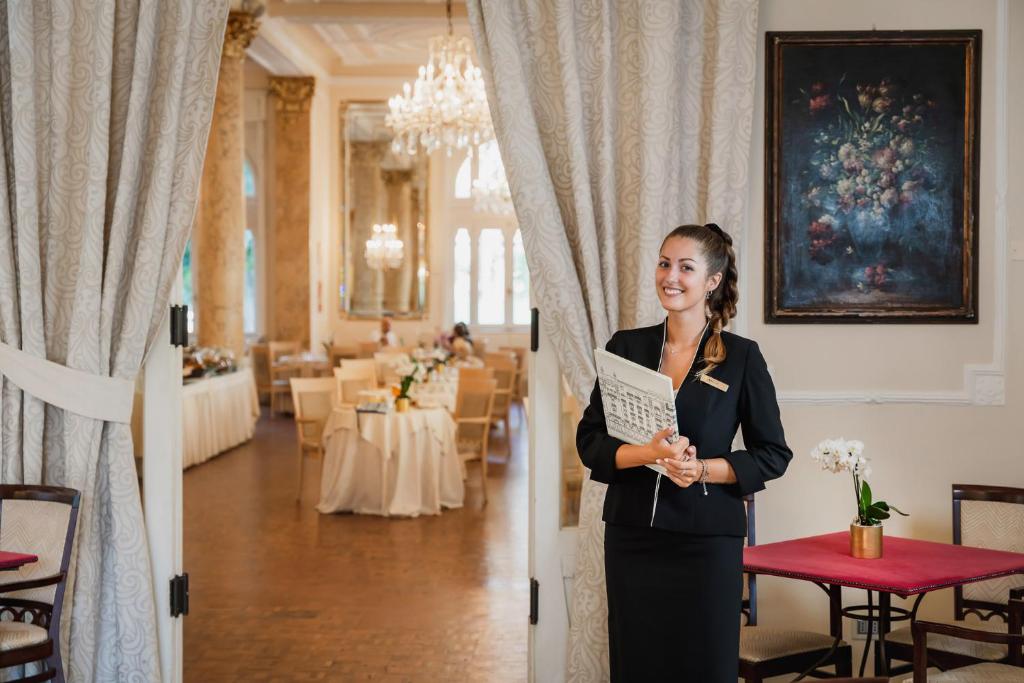 une femme en costume debout dans une pièce dans l'établissement Grand Hotel Rimini, à Rimini 130 autres photos
