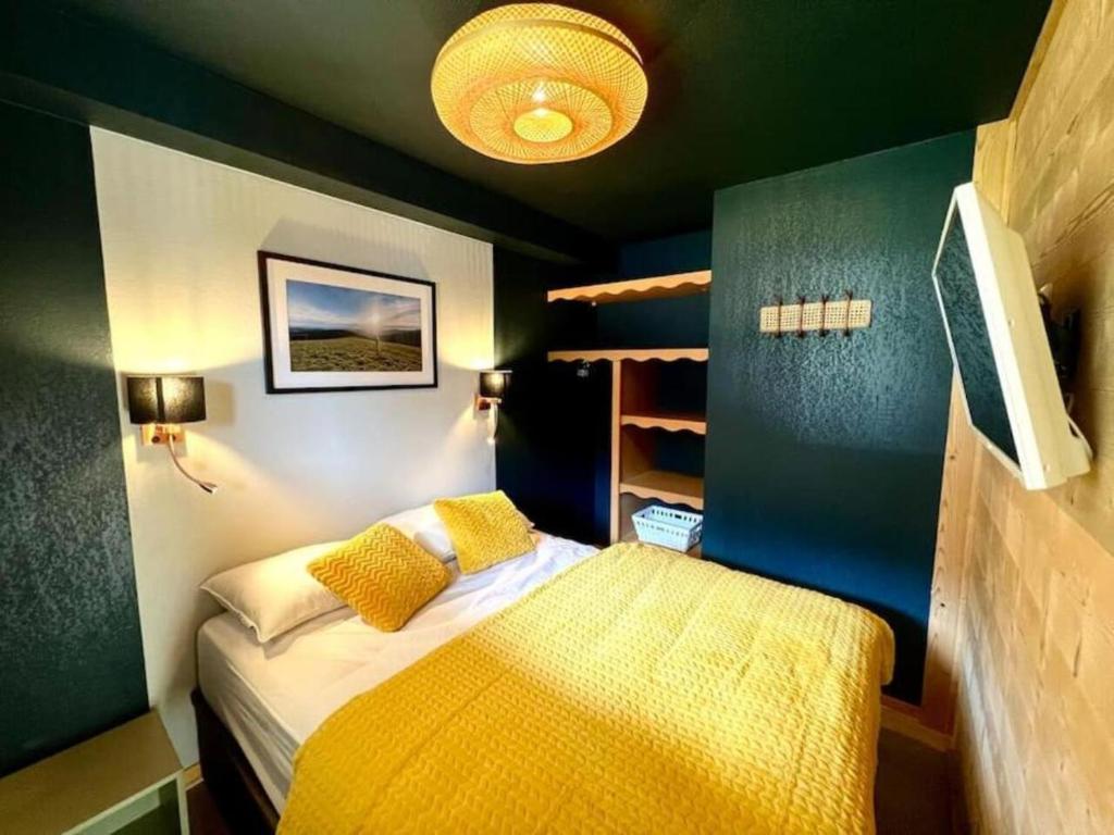 - une petite chambre avec un lit et des oreillers jaunes dans l'établissement Centre station 1800 - 2 Chambres - Vue panoramique, aux Orres