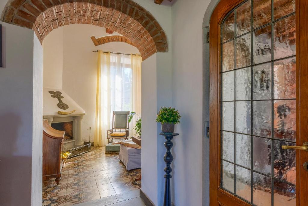 un couloir avec une arche et une porte avec une plante dans l'établissement Villa Maria - in the hills above Florence, à Castiglione
