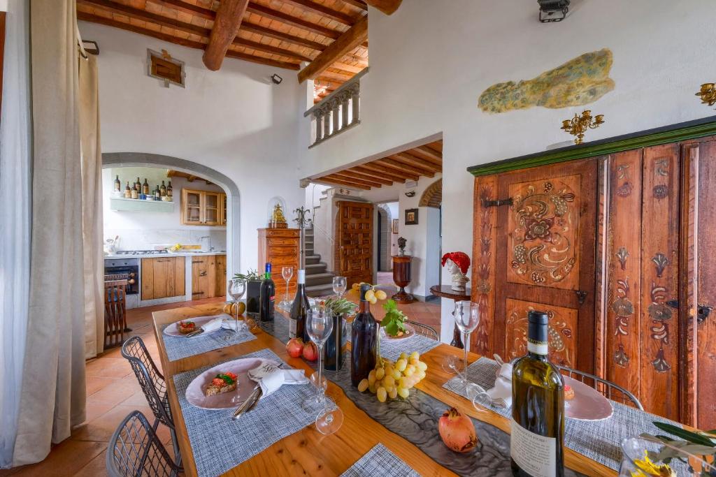 - une salle à manger avec une table et une bouteille de vin dans l'établissement Villa Maria - in the hills above Florence, à Castiglione