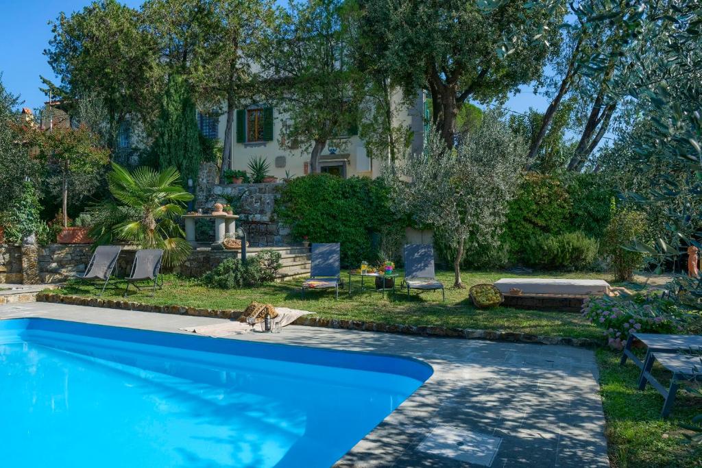 une piscine bleue devant une maison dans l'établissement Villa Maria - in the hills above Florence, à Castiglione