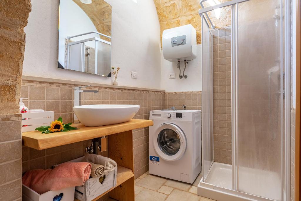 une salle de bain avec un lavabo et une machine à laver dans l'établissement Trullo Delle Ginestre Private Pool - Happy Rentals, à Latiano 20 autres photos