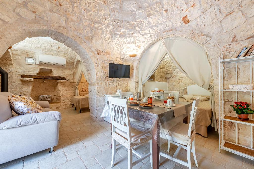 un salon avec une table, des chaises et un canapé dans l'établissement Trullo Delle Ginestre Private Pool - Happy Rentals, à Latiano
