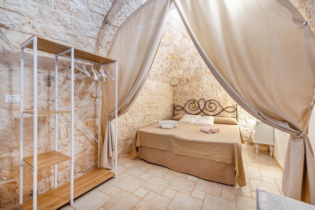 une chambre avec un lit dans un mur de pierre dans l'établissement Trullo Delle Ginestre Private Pool - Happy Rentals, à Latiano