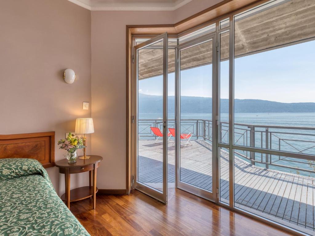 une chambre avec un lit et un balcon avec vue dans l'établissement Villa Cappellina, à Toscolano Maderno