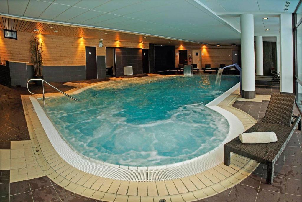une grande piscine dans une chambre d'hôtel dans l'établissement APPART ZIG-ZAG LES COCHES, à Les Coches