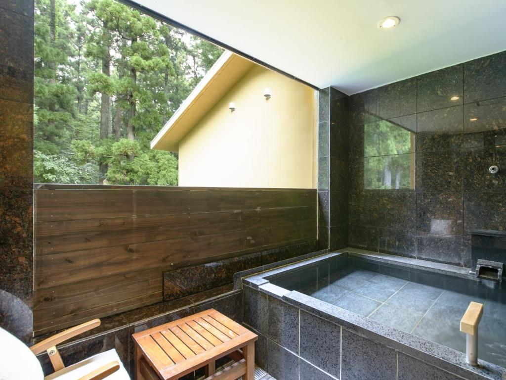 une baignoire dans une pièce avec une fenêtre dans l'établissement Hakone Suishoen, à Hakone