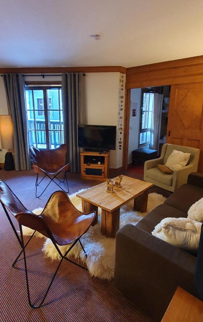 un salon avec un canapé et une table basse dans l'établissement Appartement ARC 1950 m, Ski au pied, piscine extérieure chauffée, remontées mécaniques à 100m, sauna et salle de sports, à Arc 1950