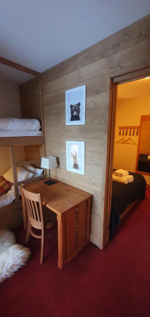 une chambre avec un bureau et une chambre avec des lits superposés dans l'établissement Appartement ARC 1950 m, Ski au pied, piscine extérieure chauffée, remontées mécaniques à 100m, sauna et salle de sports, à Arc 1950 25 autres photos