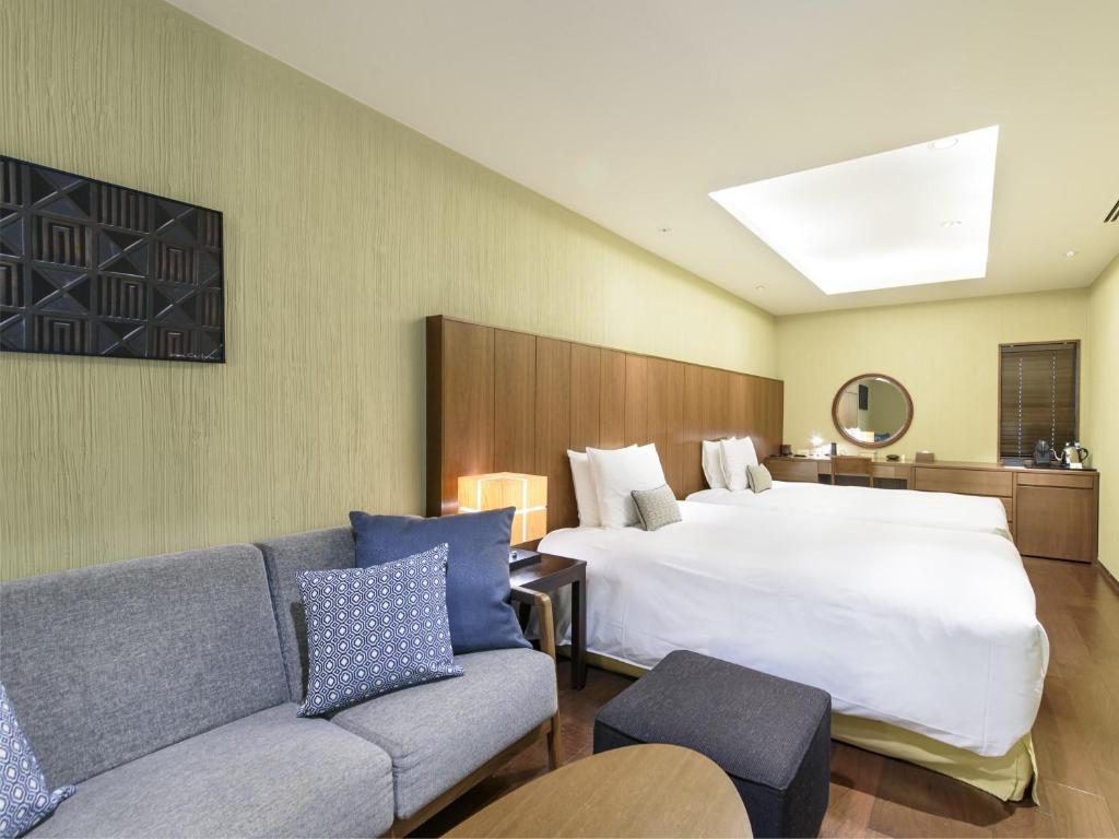 une chambre d'hôtel avec un lit et un canapé dans l'établissement Hakone Suishoen, à Hakone