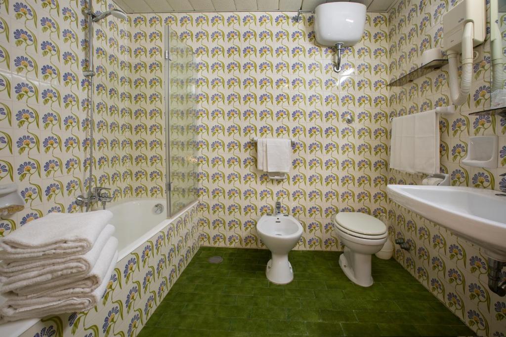 une salle de bain avec toilettes, baignoire et lavabo dans l'établissement Hotel Lido Mediterranee, à Taormine
