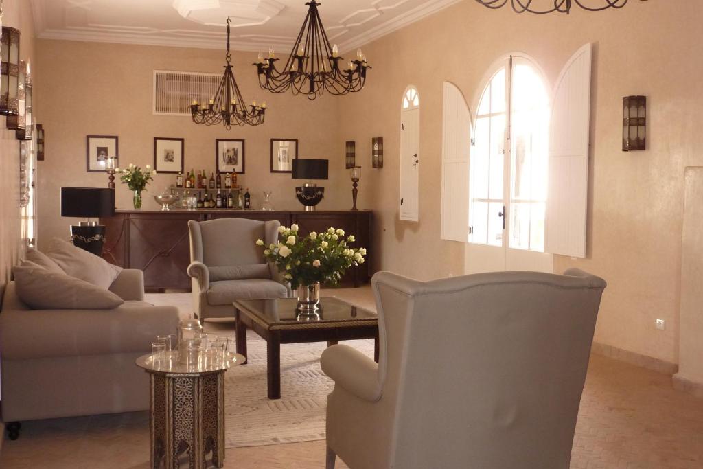 - un salon avec des chaises et une table fleurie dans l'établissement Palais Villa Talaa Resort, à Taroudant