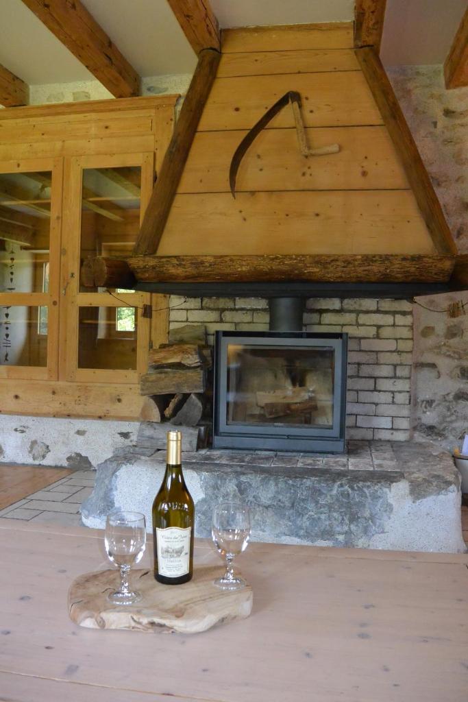 une bouteille de vin posée sur une table avec deux verres dans l'établissement Gîtes Tré Le Grenier, à Les Moussières