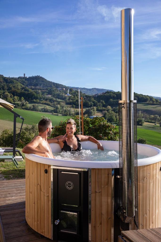un homme et une femme dans un bain à remous dans l'établissement Palazzo Serre - Natura & Piscina, à San Leo