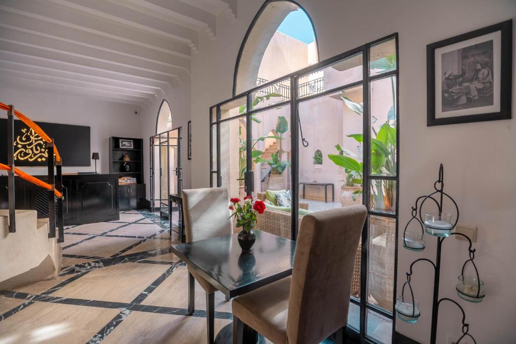 - une salle à manger avec une table et des fleurs dans l'établissement Riad & Spa Azzouz, à Marrakech