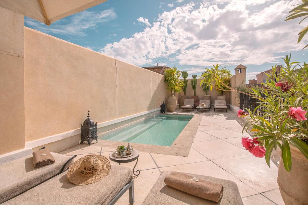 une cour avec une piscine et une terrasse dans l'établissement Riad & Spa Azzouz, à Marrakech
