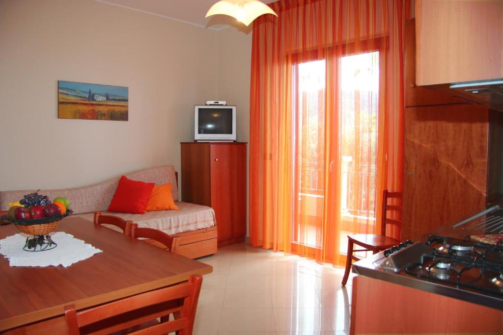 une cuisine et un salon avec un canapé et une table dans l'établissement Hotel Residence Piccolo, à Parghelia