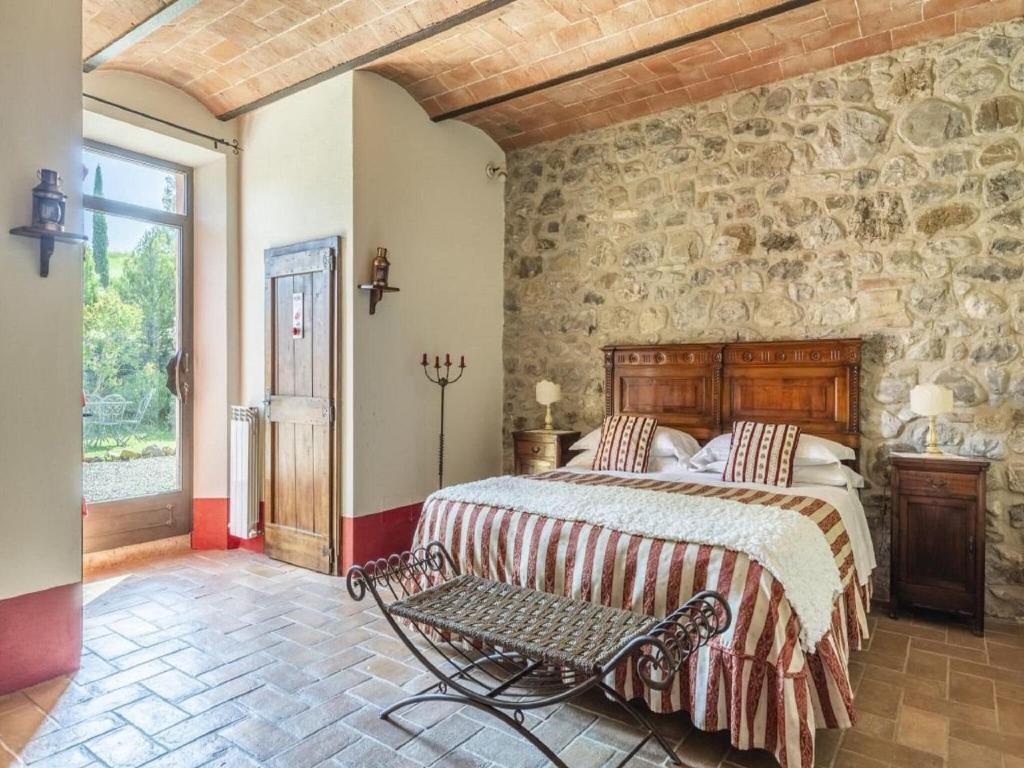 une chambre avec un lit et un mur en pierre dans l'établissement Villa Gallina Grande Stay, à Castiglione dʼOrcia 32 autres photos