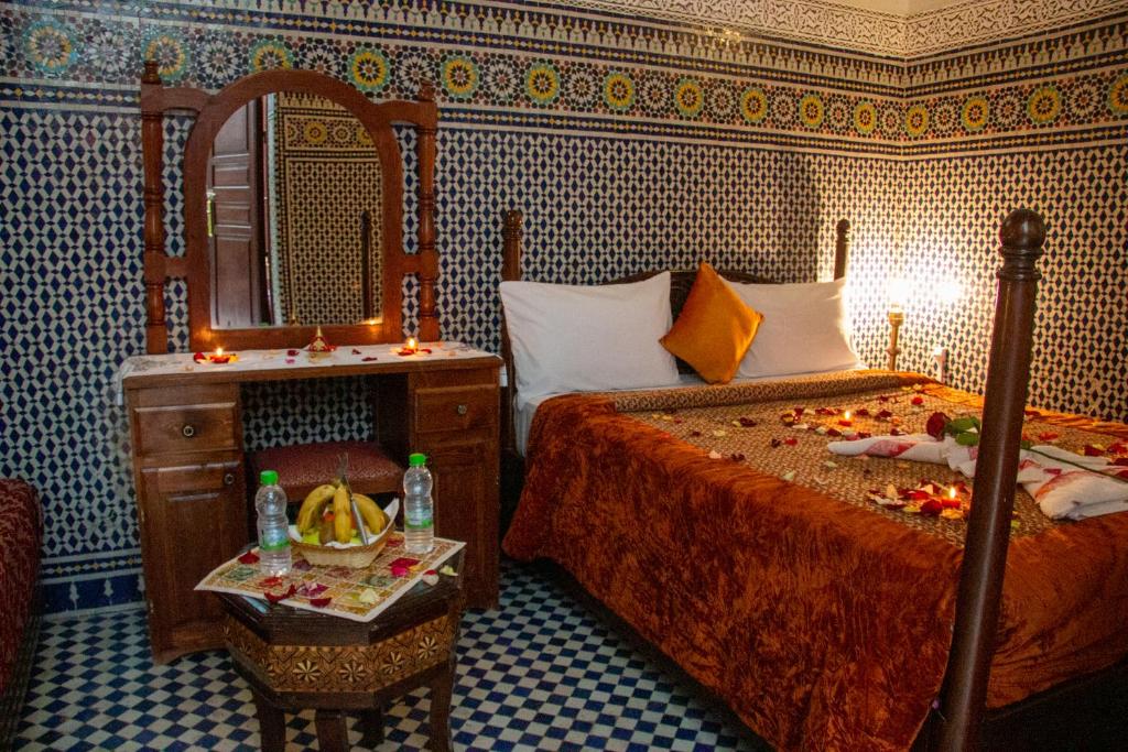 - une chambre avec 2 lits, un miroir et une table dans l'établissement Riad Baba, à Fès