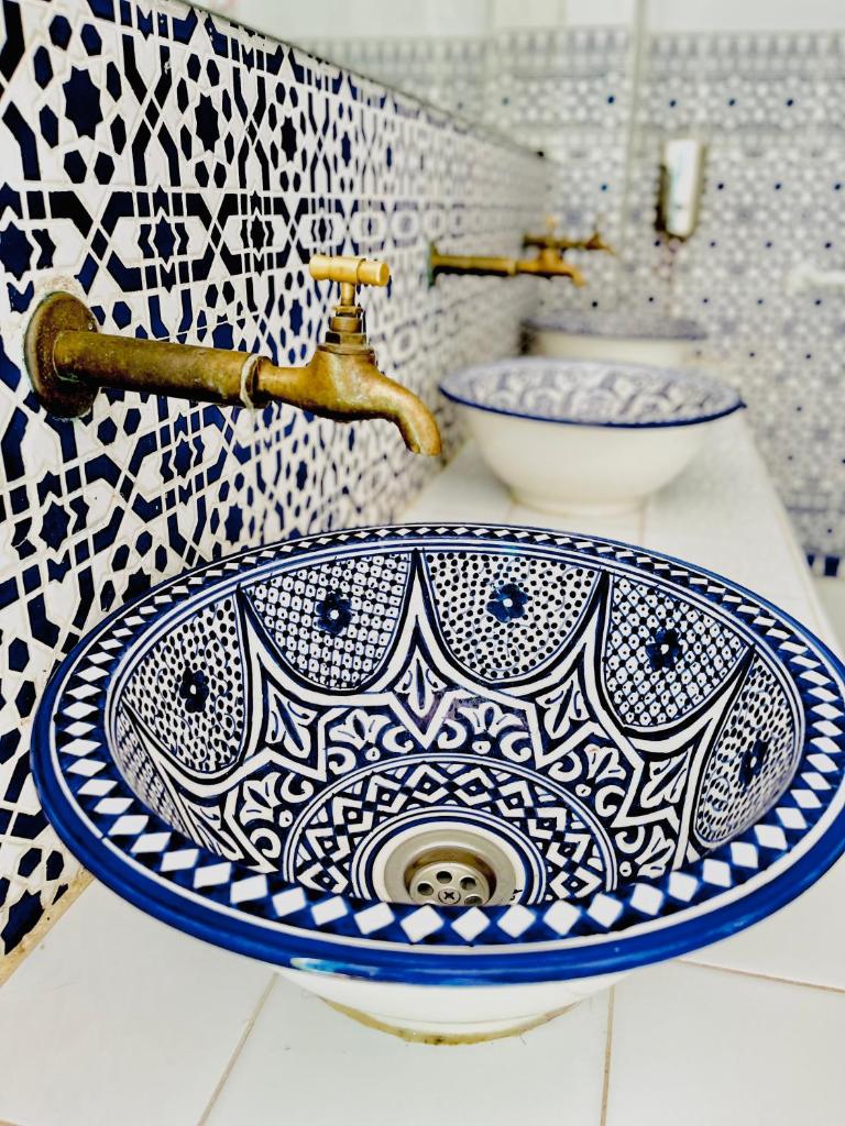 La salle de bains est pourvue d'un lavabo bleu et blanc sur un comptoir. dans l'établissement Riad Darna, à Tetouan 37 autres photos