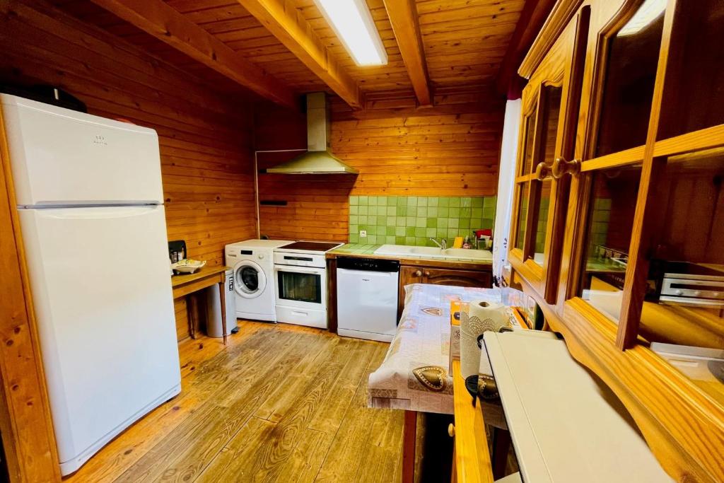 Il comprend une cuisine avec un réfrigérateur blanc et des murs en bois. dans l'établissement Beautiful chalet near the center of Briançon, à Briançon