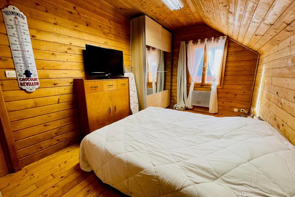 une chambre avec un lit dans une pièce en bois dans l'établissement Beautiful chalet near the center of Briançon, à Briançon