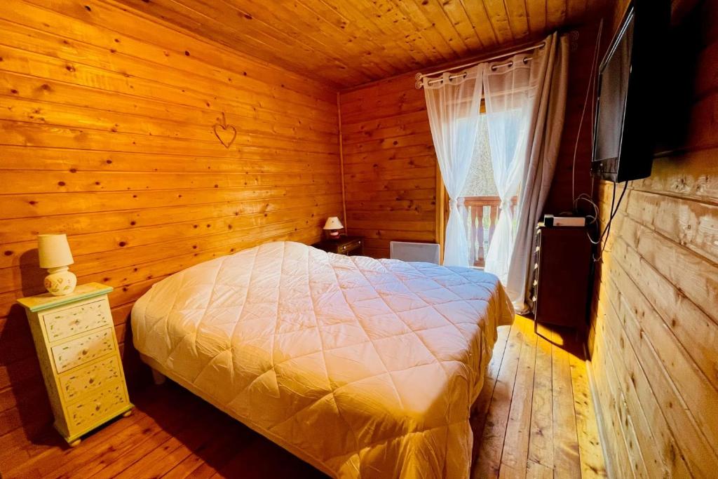 une chambre avec un lit dans une pièce en bois dans l'établissement Beautiful chalet near the center of Briançon, à Briançon