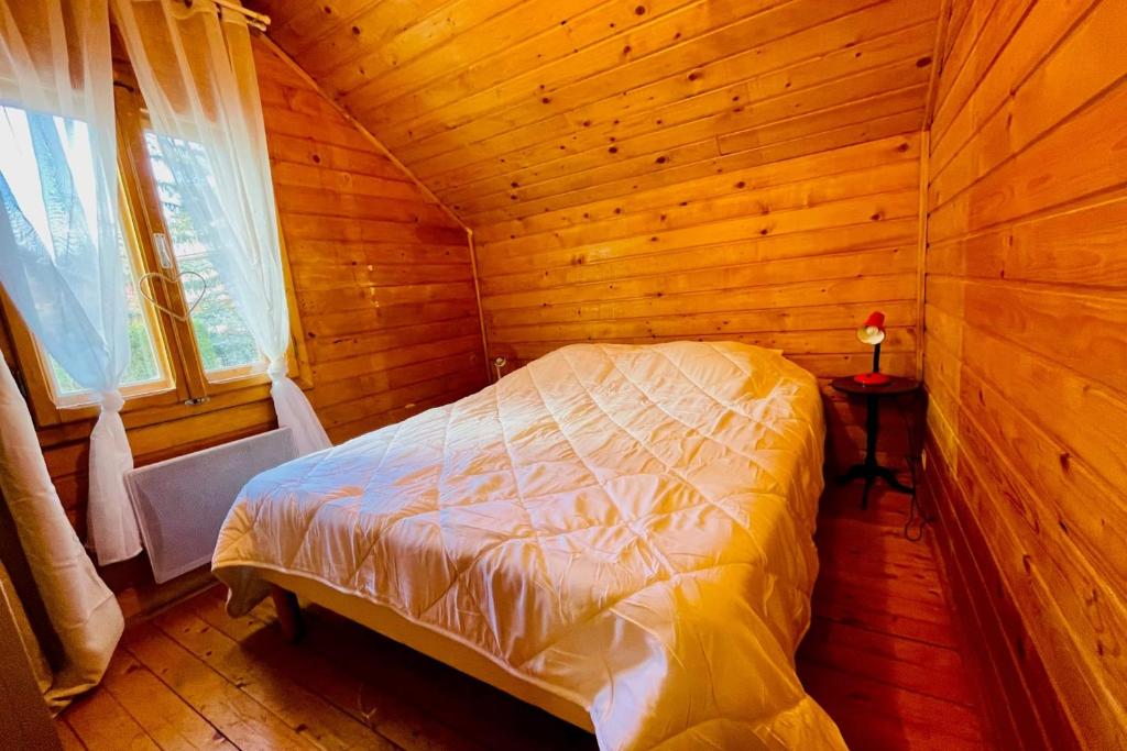 une chambre avec un lit dans une cabane en bois dans l'établissement Beautiful chalet near the center of Briançon, à Briançon 9 autres photos