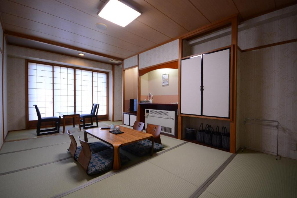 une pièce avec une table et des chaises et une salle à manger dans l'établissement Nasushiobara Ichimantei, à Nasushiobara