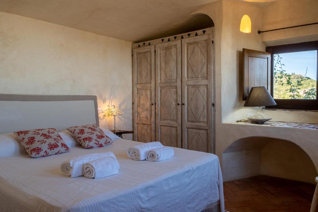 une chambre avec un lit avec des serviettes dessus dans l'établissement Lussuosa villa con Piscina opera dell'Arch.Couelle, à Porto Cervo