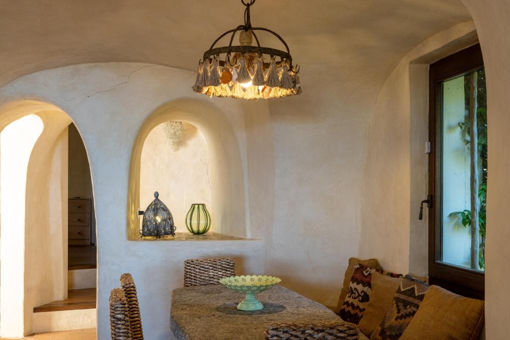 une salle à manger avec une table et un lustre dans l'établissement Lussuosa villa con Piscina opera dell'Arch.Couelle, à Porto Cervo