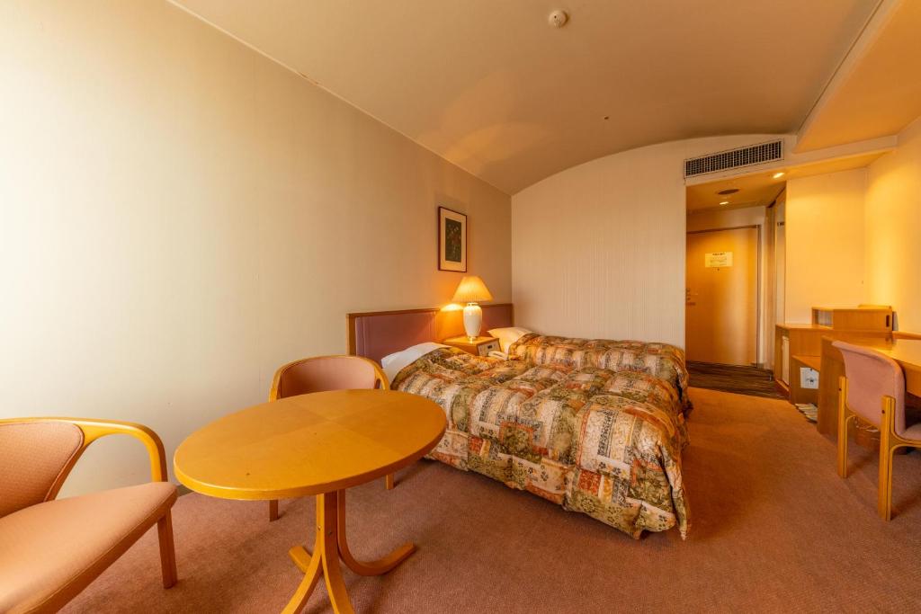 une chambre d'hôtel avec un lit, une table et des chaises dans l'établissement Kasuitei, à Yonago 37 autres photos