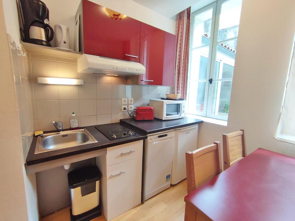 une petite cuisine avec un évier et une table dans l'établissement Pat 83, T2, centre Luchon, wifi, casier à skis, 4 personnes, à Luchon 1 autre photo