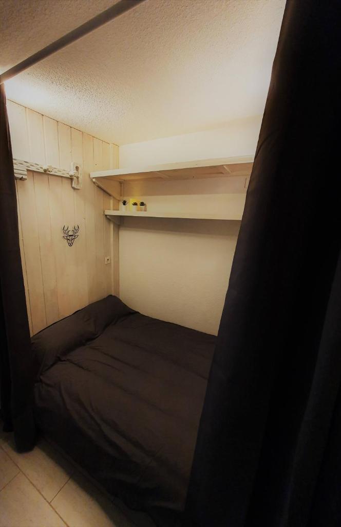Cette petite chambre comprend un lit et des étagères. dans l'établissement Le Choucas, à Risoul