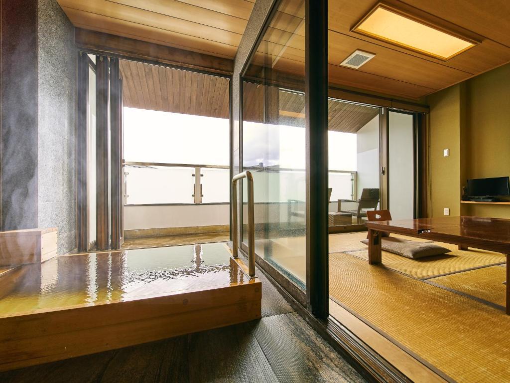 une pièce avec une porte vitrée et une table dans l'établissement Kannawaen, à Beppu