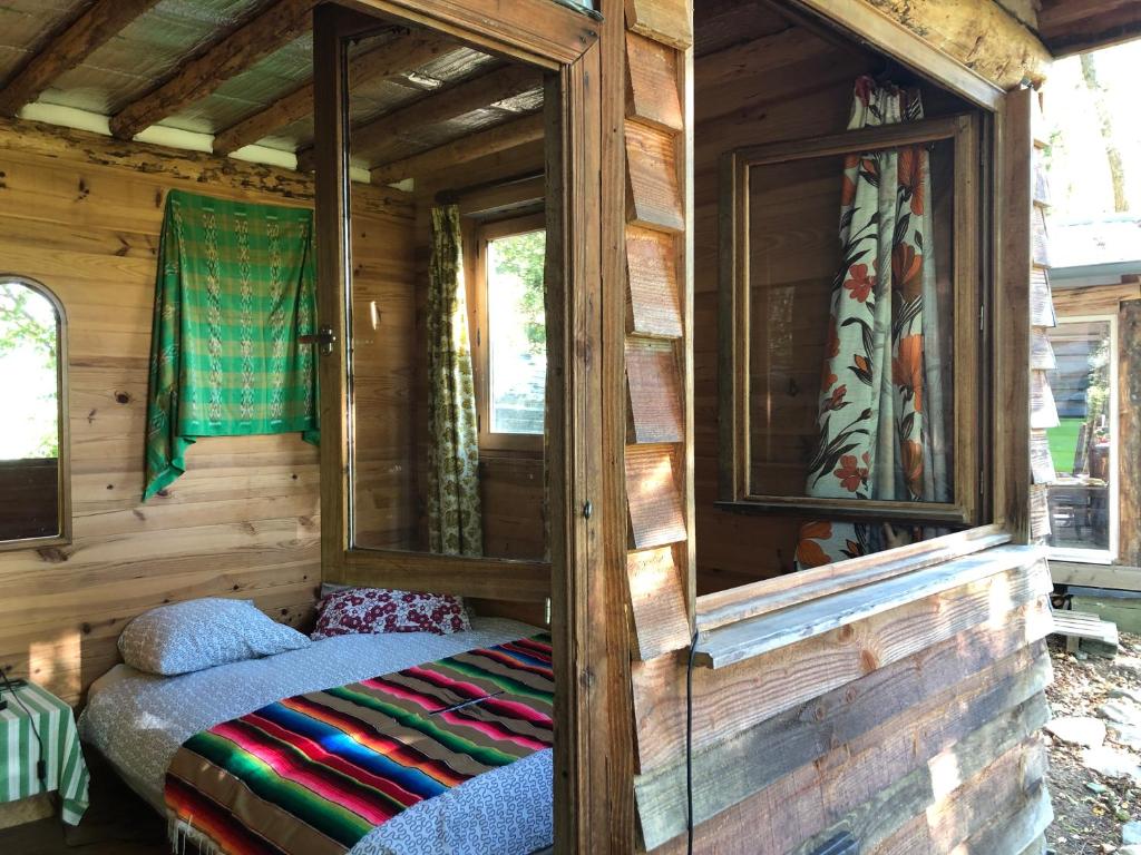 Cette chambre comprend un lit dans une cabane en bois. dans l'établissement Fenêtre sur les Pyrénées, à Soulan