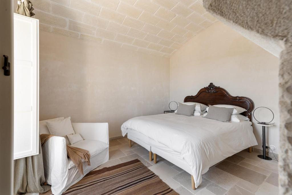 une chambre blanche avec un lit et une chaise dans l'établissement Villa Margareta, à Ostuni 47 autres photos