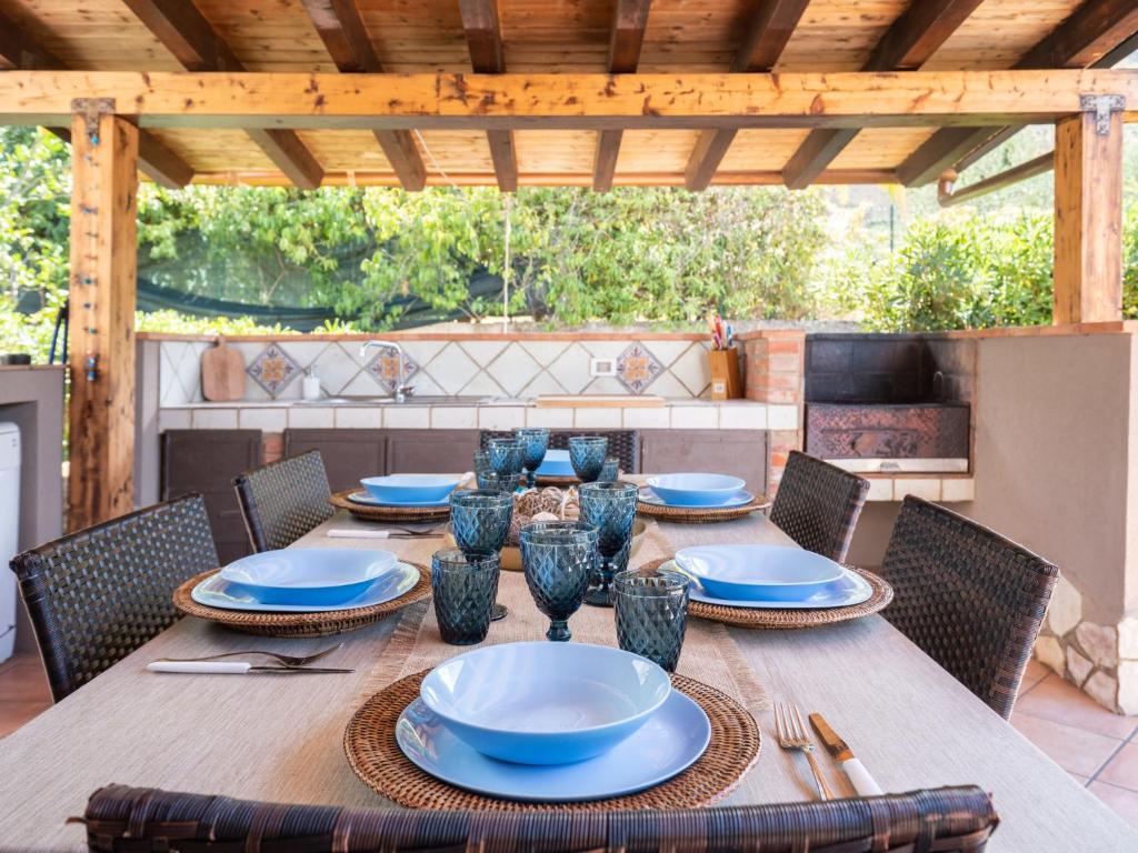 d'une table en bois avec des chaises et des plaques bleues. dans l'établissement Villa Nicole con Dependance by Interhome, à Castellammare del Golfo