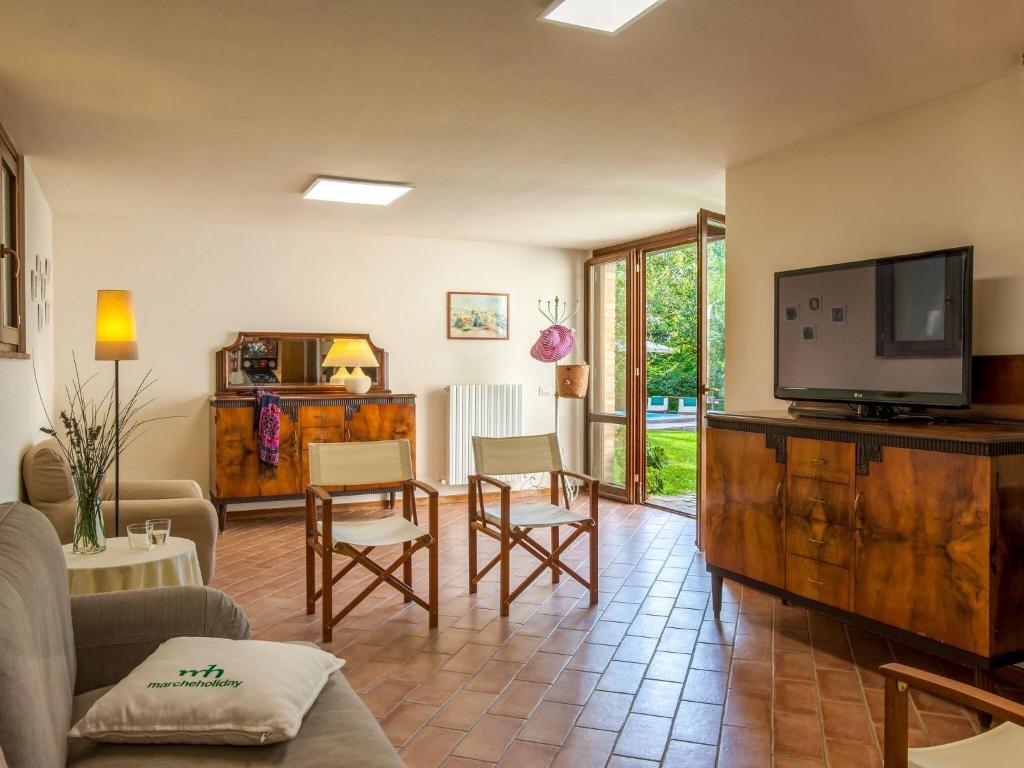 - un salon avec une télévision à écran plat dans un centre de divertissement en bois dans l'établissement Luxury Stay with Garden, à Monte San Martino