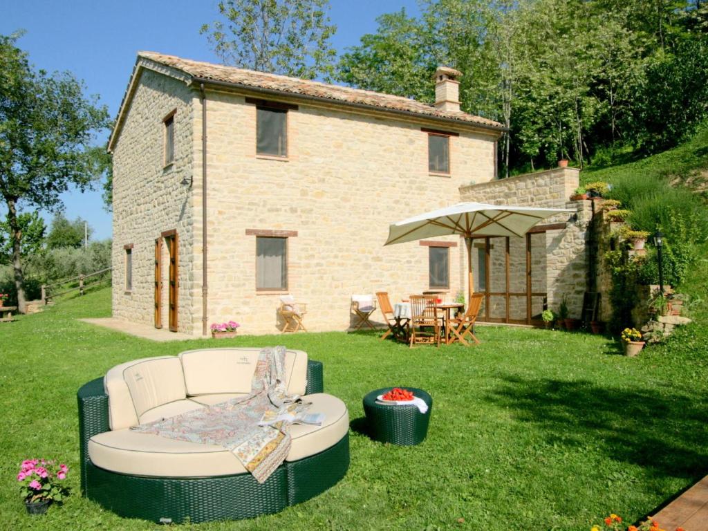 une maison avec une cour avec un canapé et une table dans l'établissement Luxury Stay with Garden, à Monte San Martino