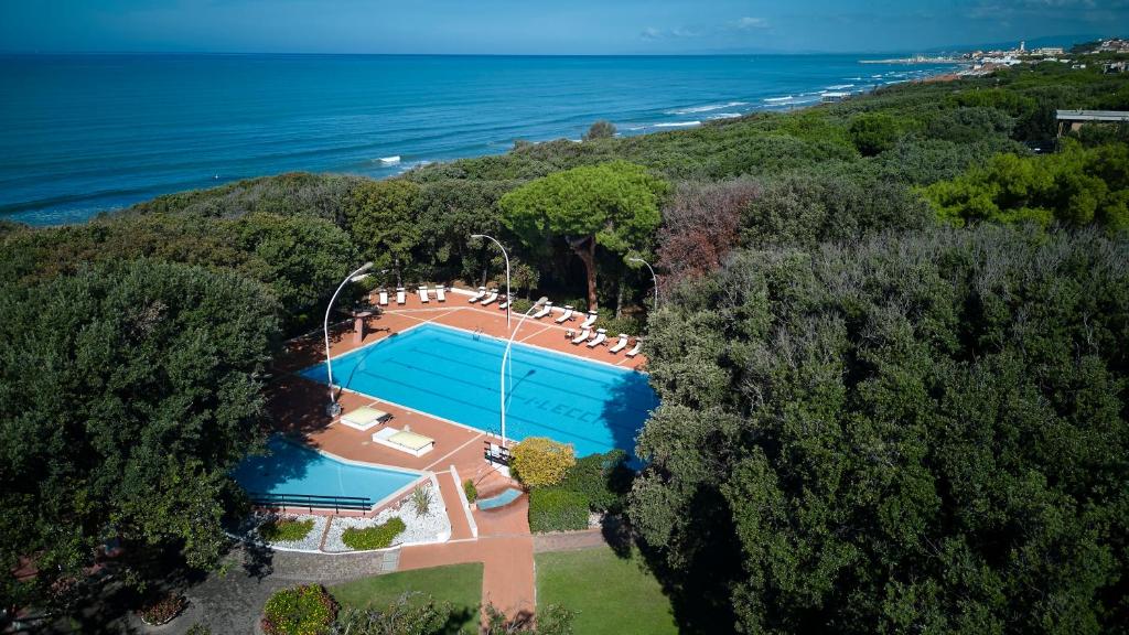 une vue aérienne d'une maison avec piscine et l'océan dans l'établissement Park Hotel I Lecci, à San Vincenzo