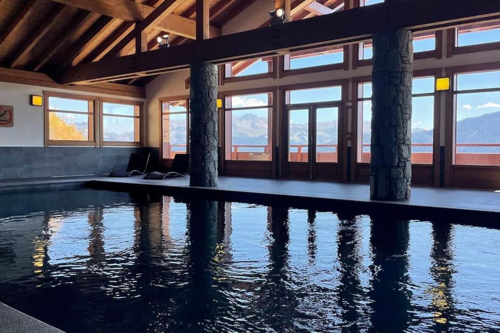 - une piscine dans un bâtiment avec fenêtres dans l'établissement La Perle des Alpes C10 Apart.4* #Yolo Alp Home, à Villard-sur-Doron