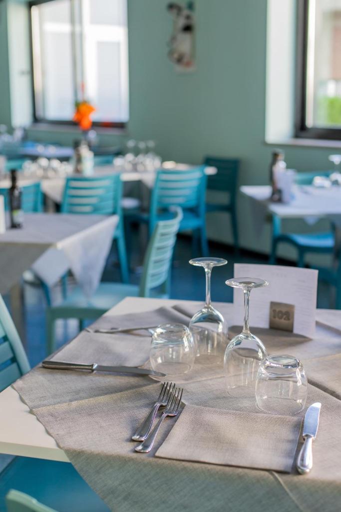 - une table avec des verres à vin et des serviettes dans l'établissement Hotel Continental, à Tortoreto Lido