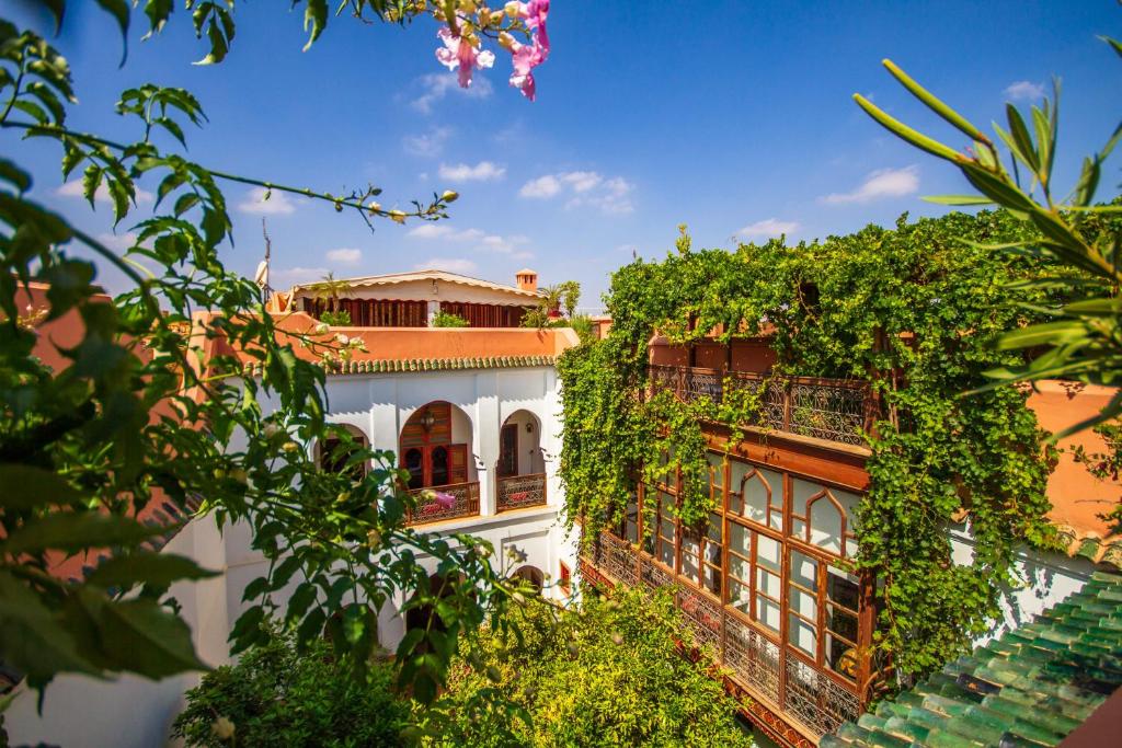 un bâtiment avec du lierre sur son côté dans l'établissement Riad Dombaraka, à Marrakech