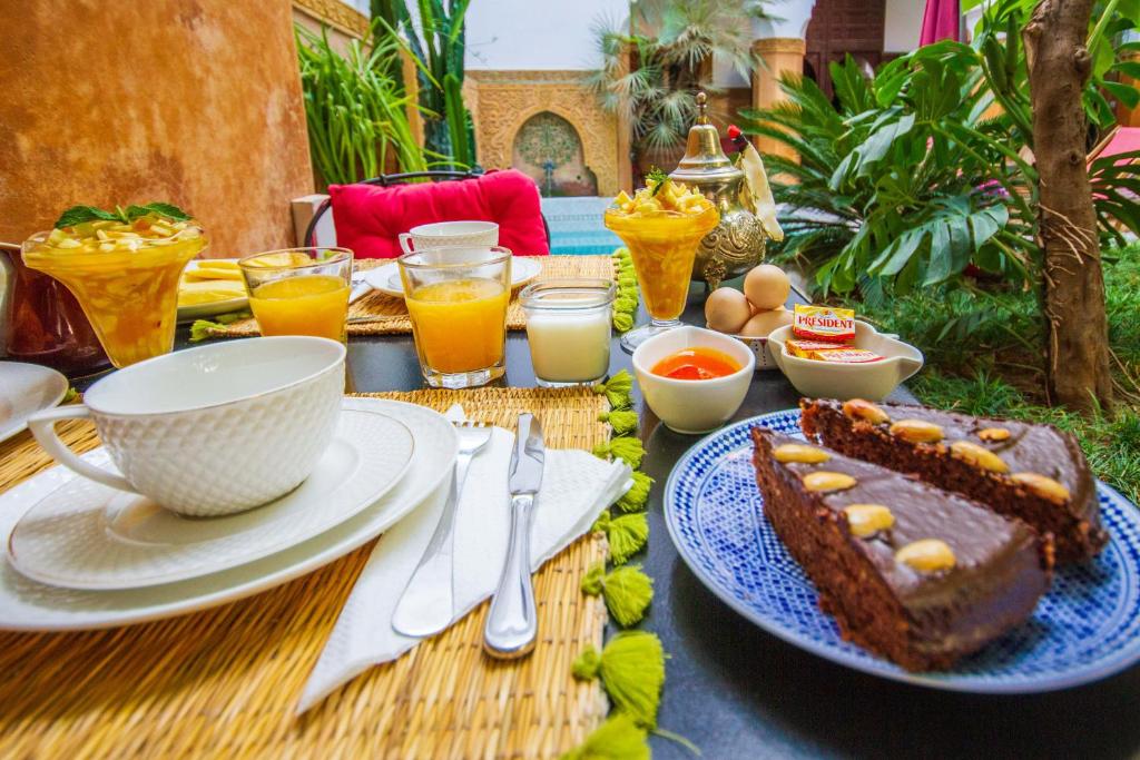 une table avec un morceau de gâteau sur une plaque bleue dans l'établissement Riad Dombaraka, à Marrakech