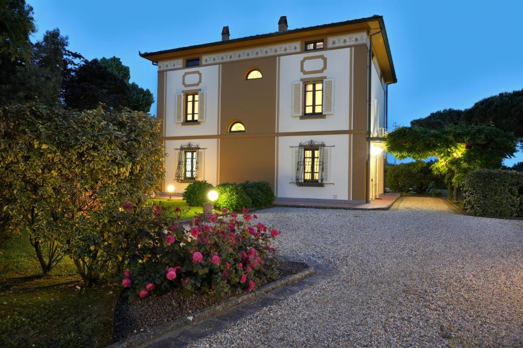 une grande maison avec des fleurs devant dans l'établissement Villa Colombai, à Orentano